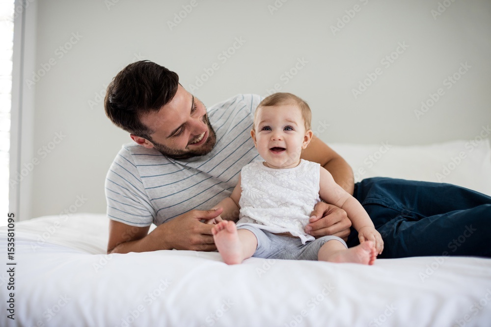 Father playing with his baby girl in bedroom Father playing with his baby girl in bedroom