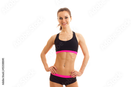 beautiful fitness girl holding hands at the sides and smiling