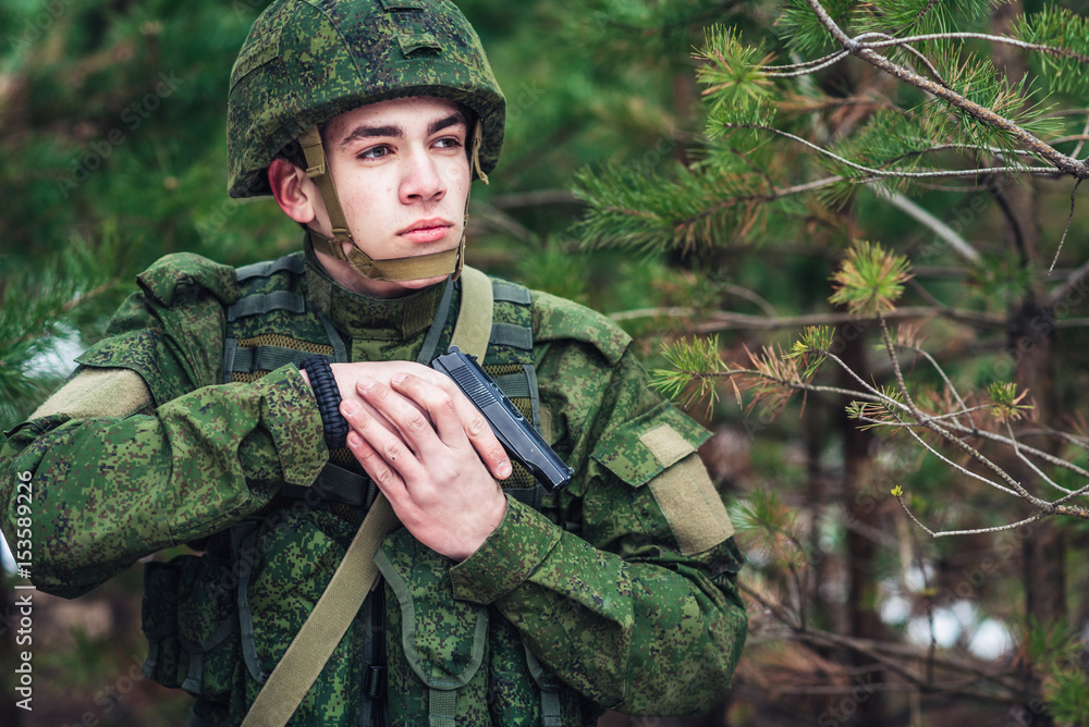 Portrait of a Russian soldier in modern military uniforms and weapons,  machine gun. Green form on the background of a pine forest Stock Photo |  Adobe Stock