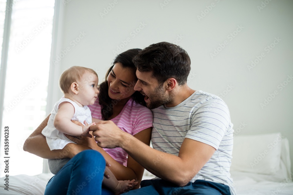 Couple playing with their baby girl in bedroom Couple playing with their baby girl in bedroom