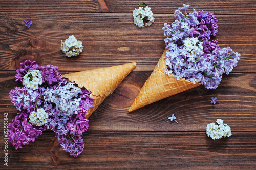 Ice cream waffle cones with lilac flowers photo