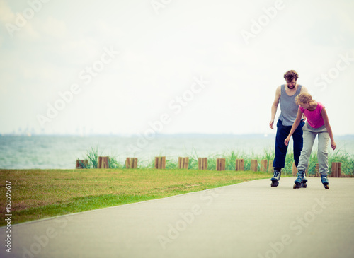 Young couple holding hands while rollerblading