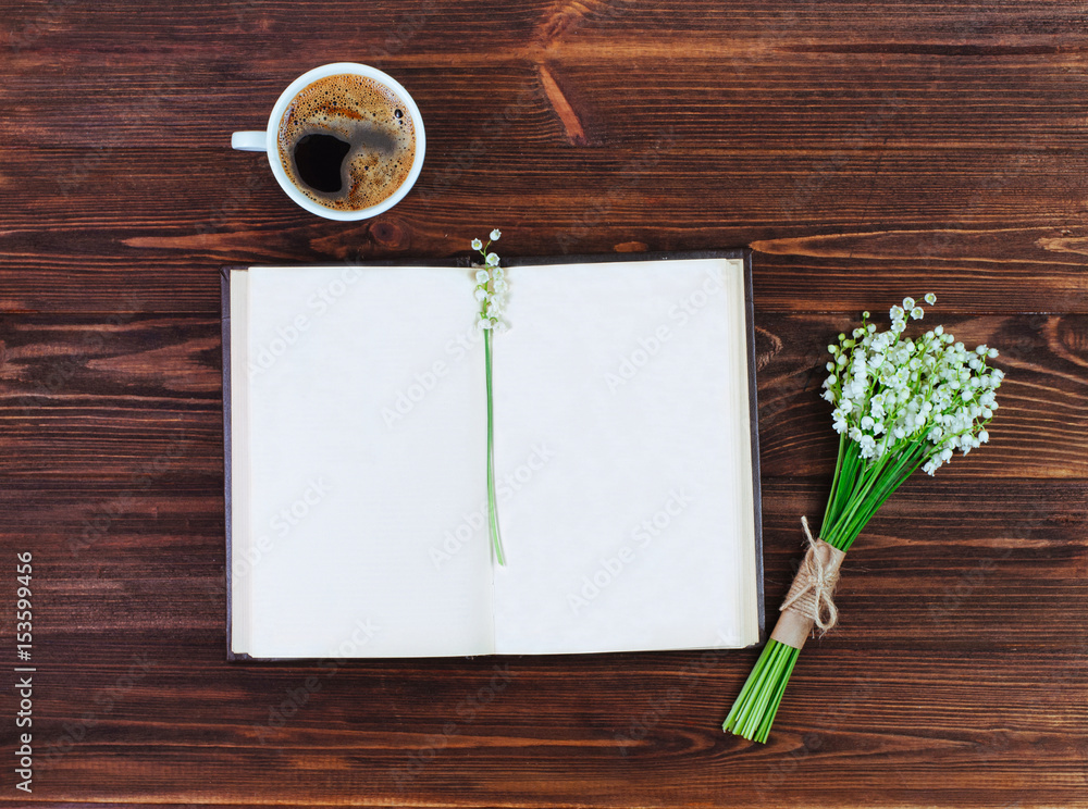 Open book with blank space for text near cup of coffee and lilies flowers