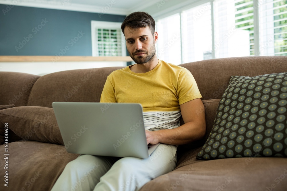 Man using laptop in living room Man using laptop in living room
