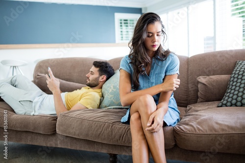 Couple ignoring each other in living room