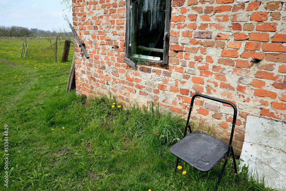 Tary rural building in the wilderness and lonely chair