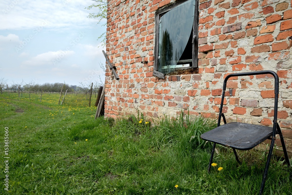Tary rural building in the wilderness and lonely chair