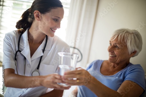 Wallpaper Mural Doctor serving a water glass to senior woman  Torontodigital.ca