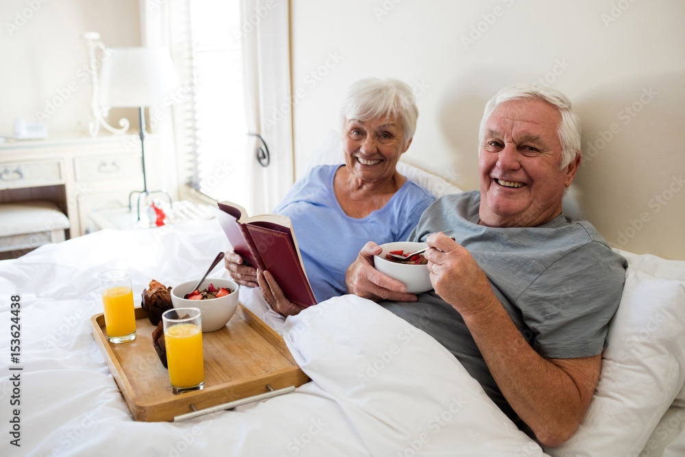 Obraz premium Senior couple having breakfast in the bedroom