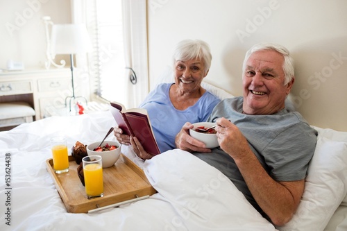 Senior couple having breakfast in the bedroom