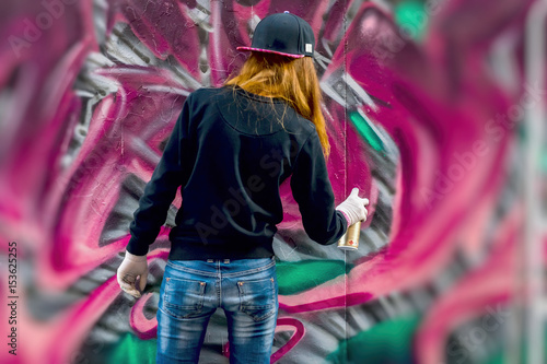 Młoda dziewczyna miejska rysuje graffiti, współczesną kultową kulturę ulicznej młodzieży. Nowoczesna kultowa ulica miejska. Koncepcja nowoczesnego designu. Graffiti sztuki ulicznej. selektywna ostrość