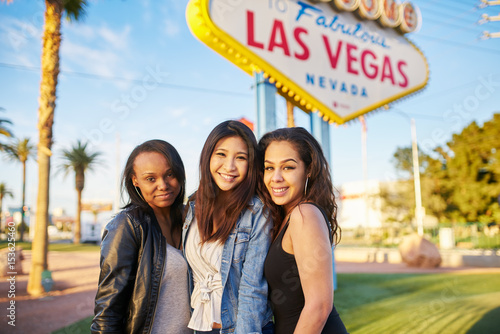 three girl friends in front of welcome to las vegas sign