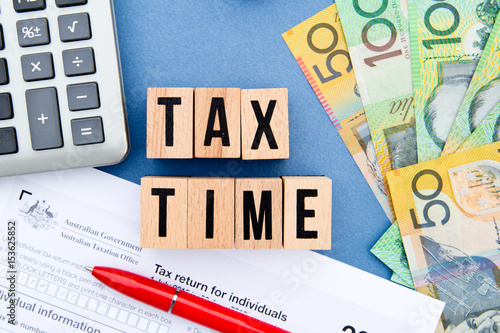 Tax Time - Australia - wooden letters with tax form, money and calculator
