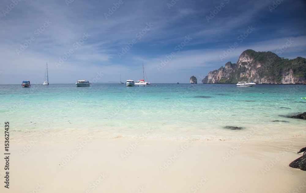 KO PHI PHI, THAILAND, February 1, 2014: Tropical beach with traditional long tail boats on the beach of Ko Phi Phi, Andaman Sea, famous tourist destination in Thailand