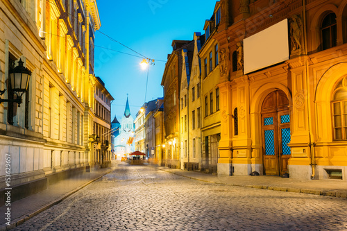 Riga Latvia. Evening View Of Deserted Pils Street, Ancient Architecture In Bright Warm Yellow Illumination © Grigory Bruev