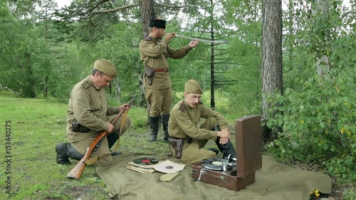 The army of the USSR. Soviet army soldiers are resting. Soldiers listen to a gramophone. Soviet Union soldiers in camp. Reconstruction of the Soviet army.
