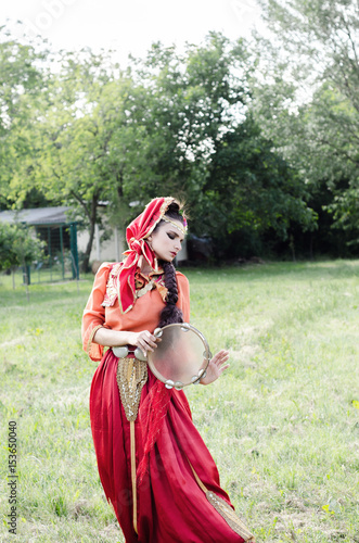 Girl in the countryside in folk costume dances