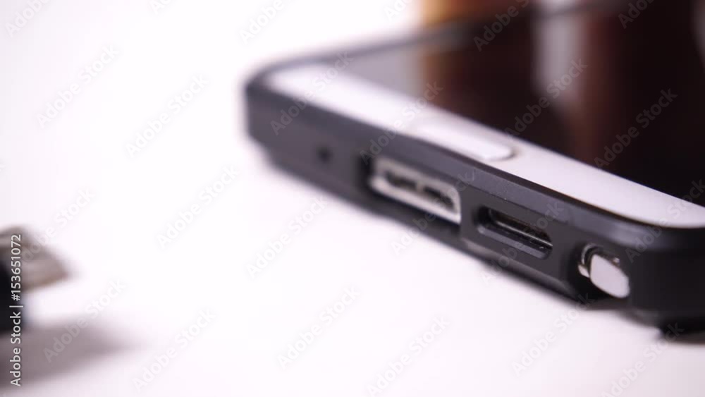 Details of male hand pushing usb cable plug into usb slot on smartphone mobile phone 4K ProRes HQ codec Details of male hand pushing usb cable plug into usb slot on smartphone mobile phone 4K ProRes HQ codec