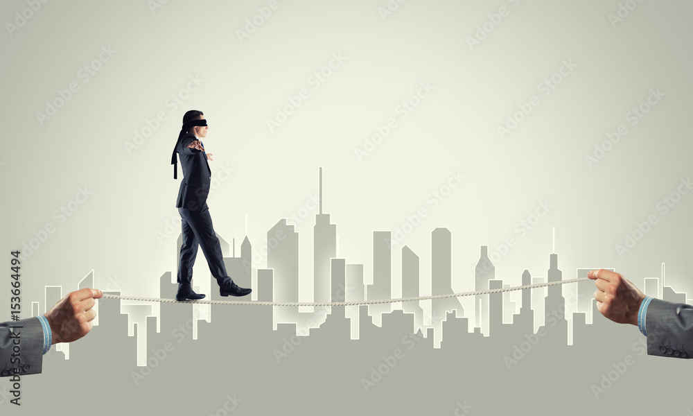 Business concept of risk support and assistance with man balancing on rope Business concept of risk support and assistance with man balancing on rope