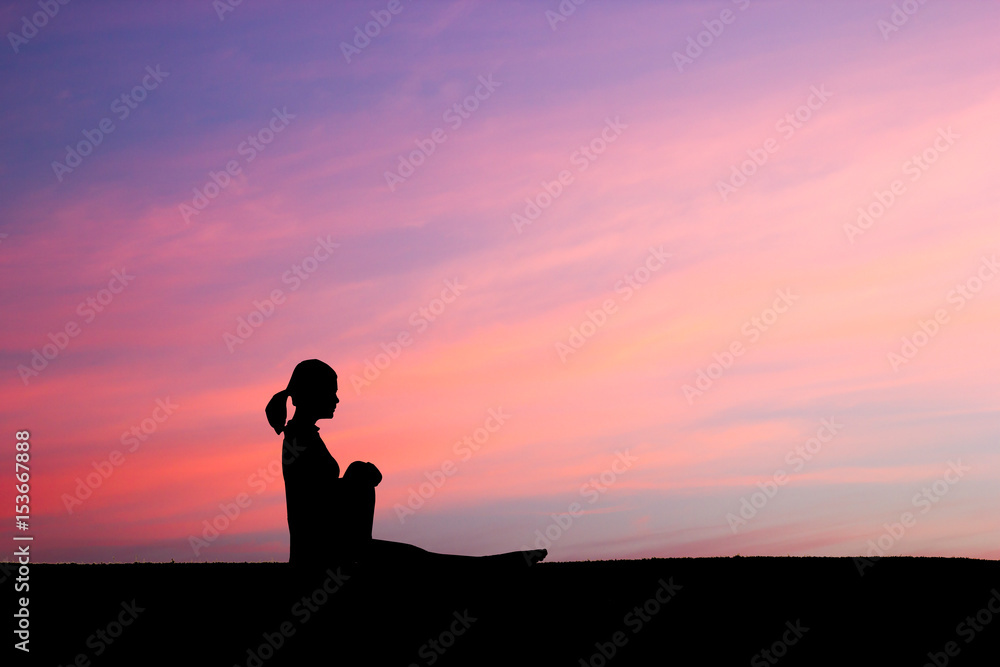 Woman practicing Spinal twist yoga pose outdoors over sunset sky background. Woman practicing Spinal twist yoga pose outdoors over sunset sky background.