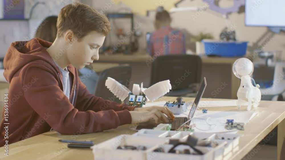 Computer Learning 8k Image Smart Young Boy Works on a Laptop For His New Robot Programing Project ...
