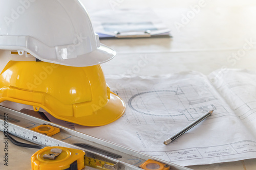 The safety helmet and the blueprint on table at construction site