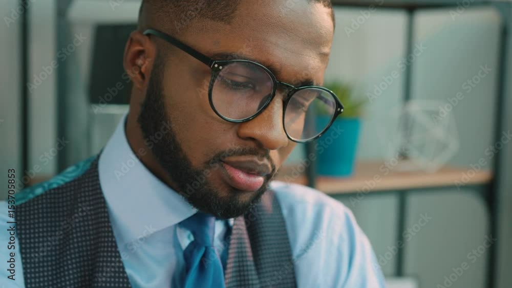 Handsome African american man working on the laptop and looking at the camera and smiling. Portrait shot. Handsome African american man working on the laptop and looking at the camera and smiling. Portrait shot.