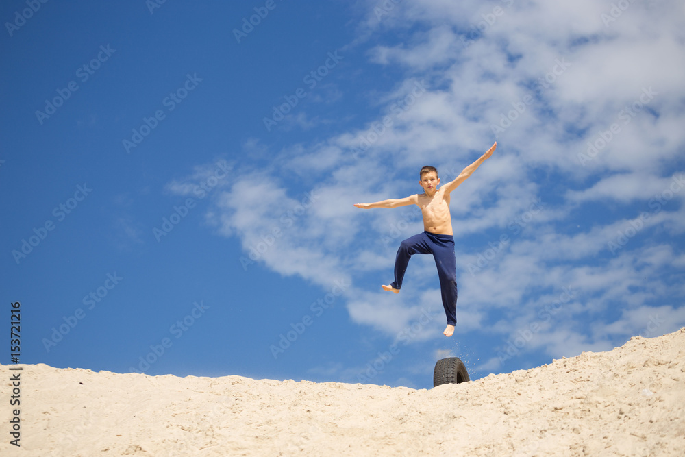 GOMEL, BELARUS - May 13, 2017: Teens study parkour on their own. Acrobatics in the sand. GOMEL, BELARUS - May 13, 2017: Teens study parkour on their own. Acrobatics in the sand.