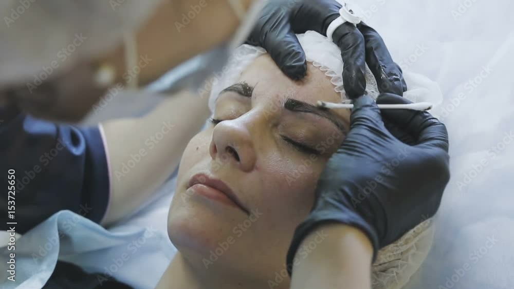 A female employee of a cosmetology clinic makes a microblasting routine to a female patient A female employee of a cosmetology clinic makes a microblasting routine to a female patient