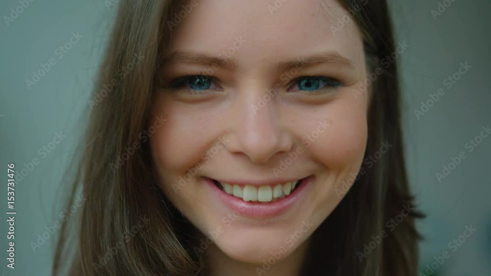Portrait of attractive young brunette girl looking forward at camera and smiling. Close up shot Portrait of attractive young brunette girl looking forward at camera and smiling. Close up shot