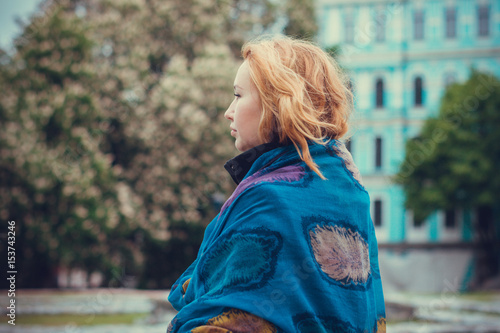 A woman in a European city  walks in a black coat at autumn and examines the neighborhood
 photo