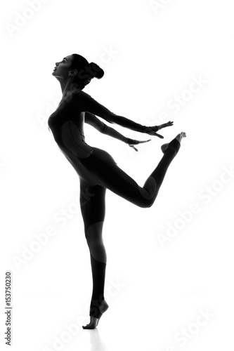 Free and healthy. Silhouette of a elegant fit female gymnast posing gracefully