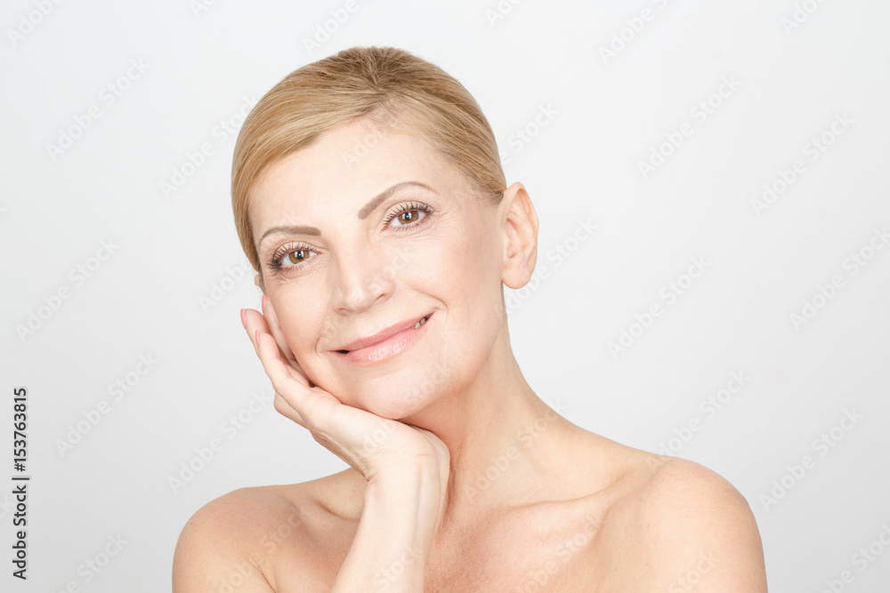 Beautiful forever. Portrait of a beautiful mature woman posing in studio with her hand to her face Beautiful forever. Portrait of a beautiful mature woman posing in studio with her hand to her face