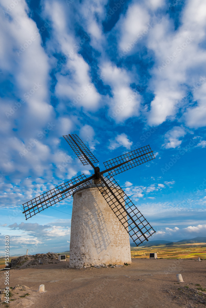Ancient windmill on hill top with rural landscape