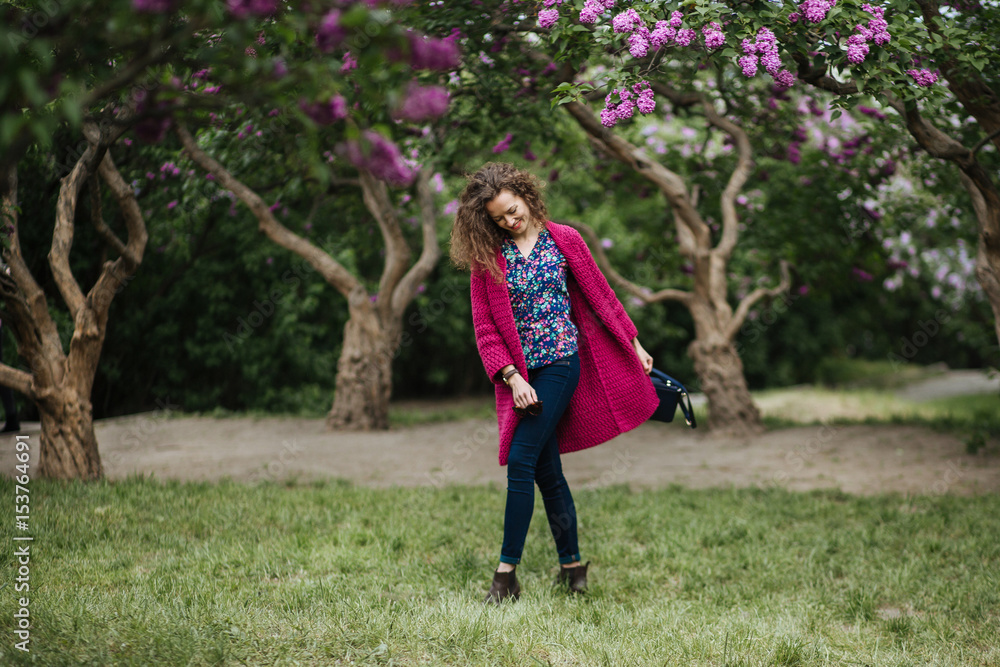 Woman around a lilac pink flowers tree in a spring garden Woman around a lilac pink flowers tree in a spring garden