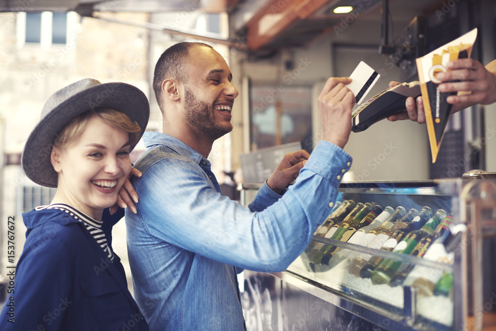 Fotografie Young man doing contactless payment for fries