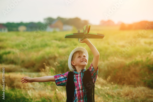 a boy plays with a model airplane during sunset. Dream to be a pilot