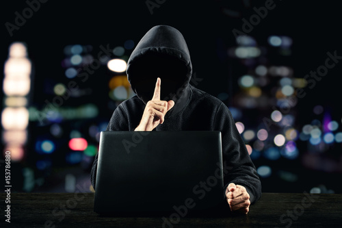 Hacker in front of his computer. Dark face