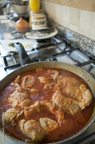 Foto cooking marrowbone in pan with tomato sauce