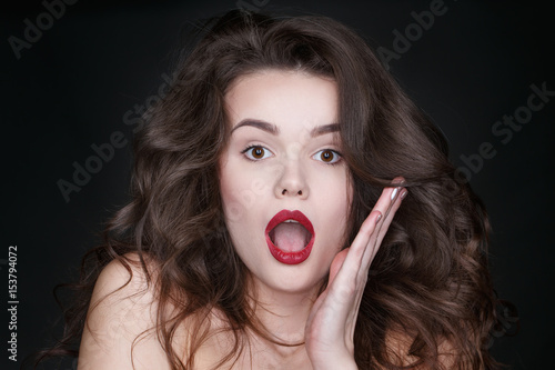 Beauty in emotions. Studio shot of a charming young surprised female looking shocked on black background.