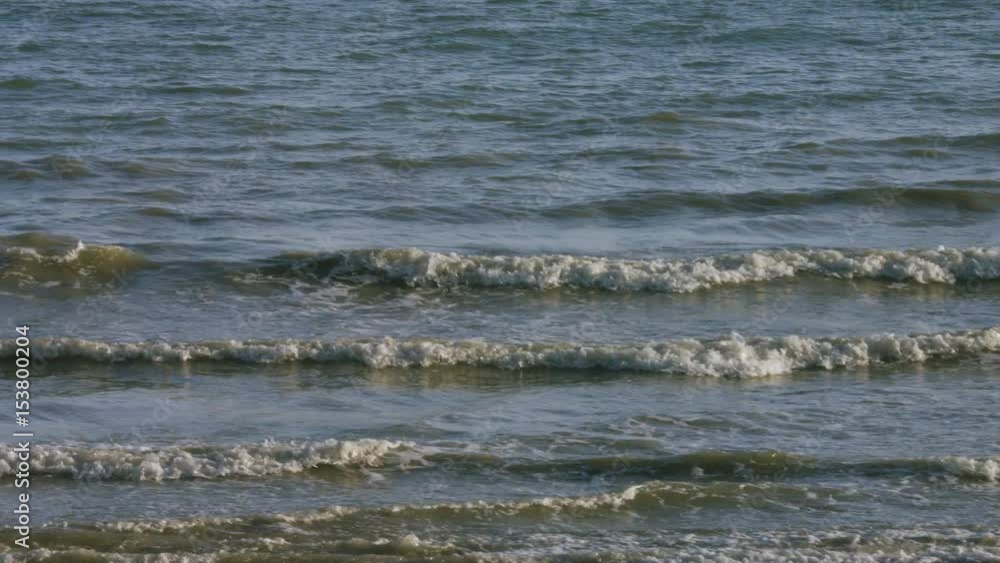 Panning shot of waves coming up to the shoreline Panning shot of waves coming up to the shoreline