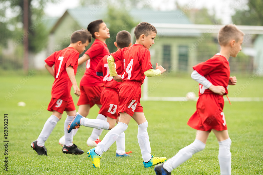 Obraz premium Kids soccer football - children players exercising before match on soccer field