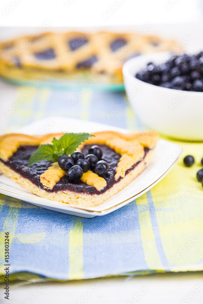 Piece of a blueberry pie and fresh berries on a wooden table. Piece of a blueberry pie and fresh berries on a wooden table.