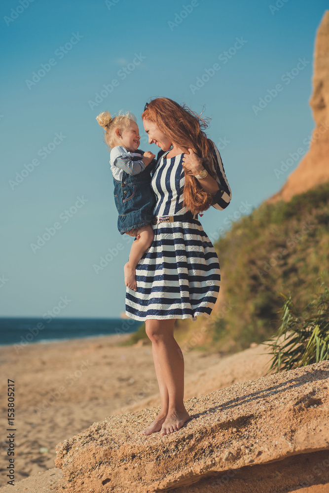 Beautifull mother lady with cute daughter girl on a beach sea side stylush dressed. Beautifull mother lady with cute daughter girl on a beach sea side stylush dressed.