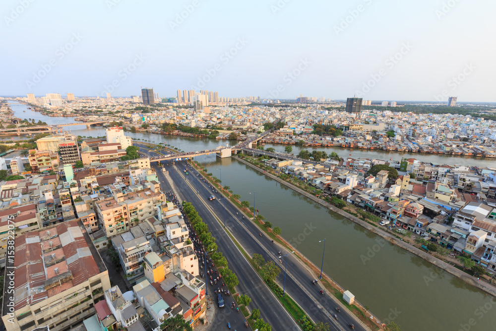 Ho Chi Minh city scape in Vo Van Kiet boulevard, canal, buildings and traffic around Cau Chu Y bridge, district 8
