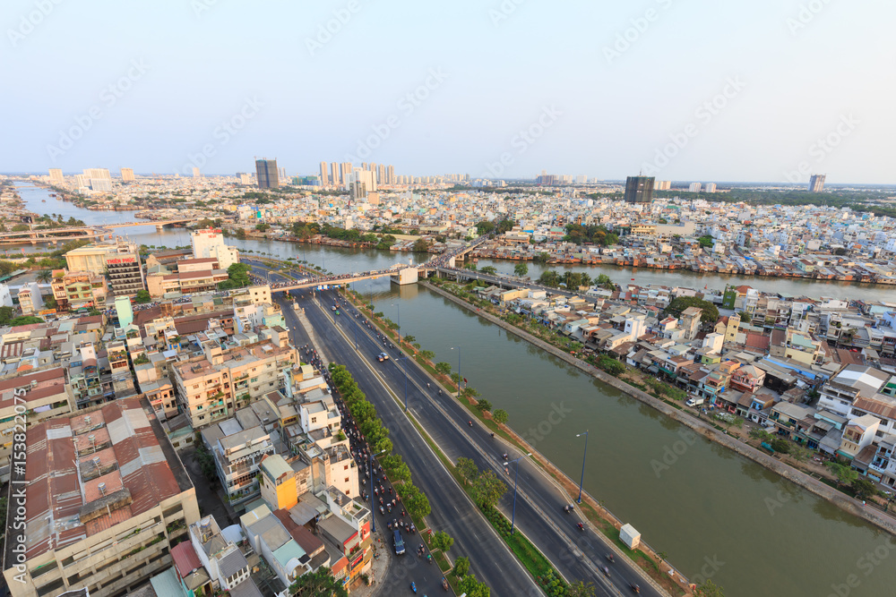 Fototapeta premium Ho Chi Minh city scape in Vo Van Kiet boulevard, canal, buildings and traffic around Cau Chu Y bridge, district 8