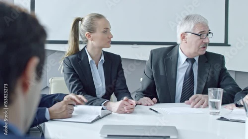 Wallpaper Mural Zoom out of senior CEO sitting at meeting table in the office and telling something to employees Torontodigital.ca