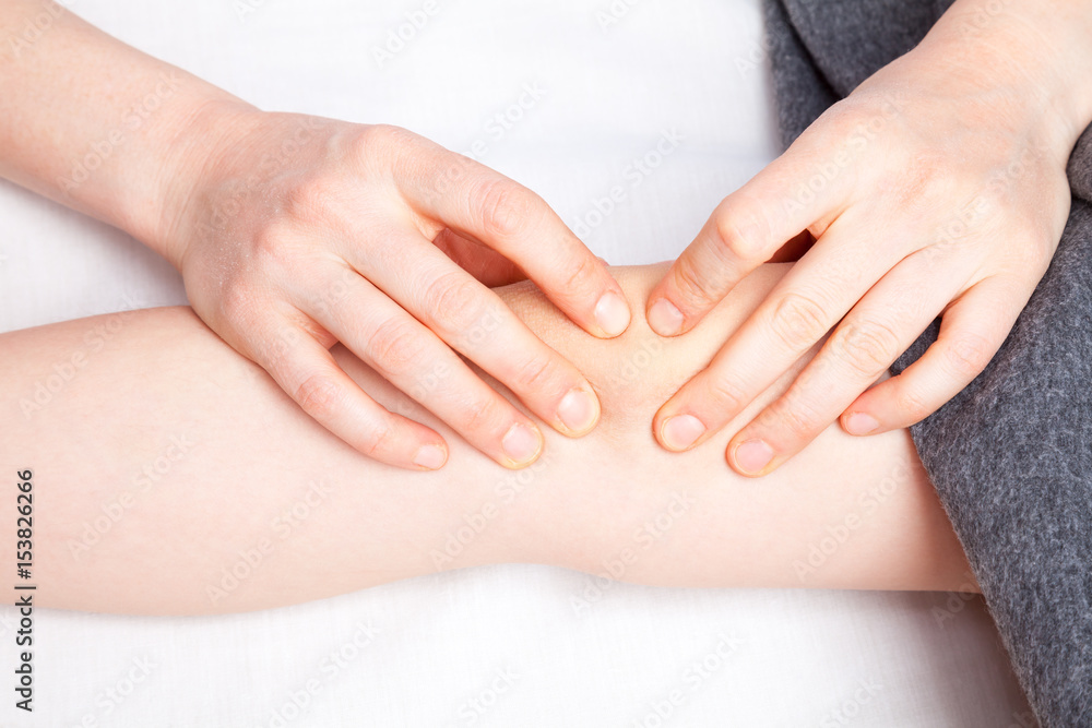 Obraz premium Girl receiving osteopathic treatment of her knee