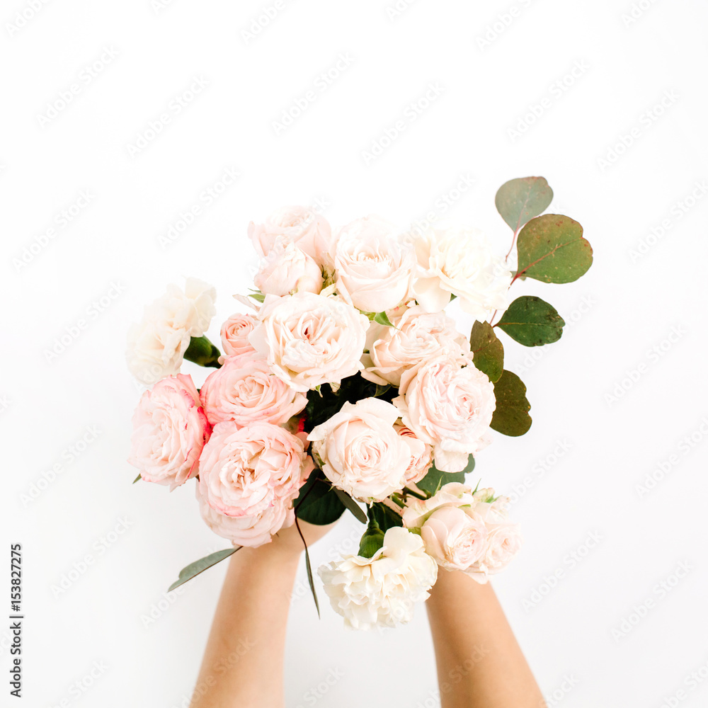 Beautiful pink rose flower and eucalyptus bouquet in girls hand isolated on white background. Flat lay, top view. Floral composition