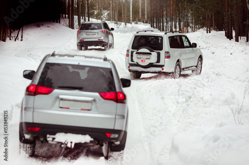 Three SUVs in the woods in winter in the rally © demphoto